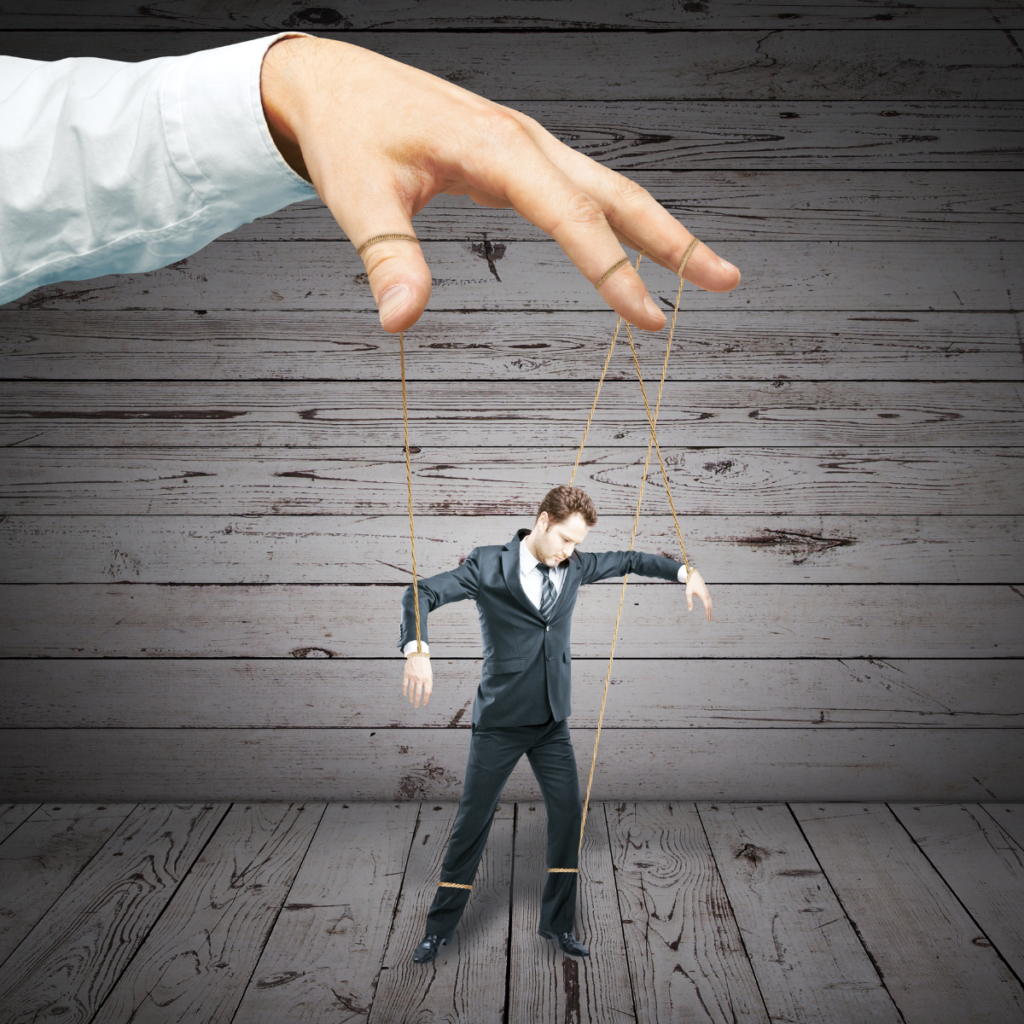 Man in suit being controlled like a puppet with strings